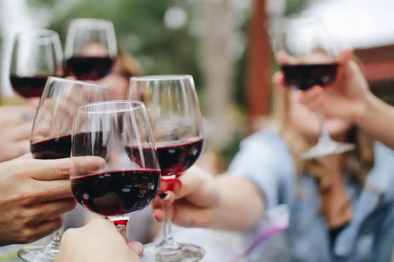 Des verres de vin rouge levés pour un apéro dinatoire convivial entre amis.