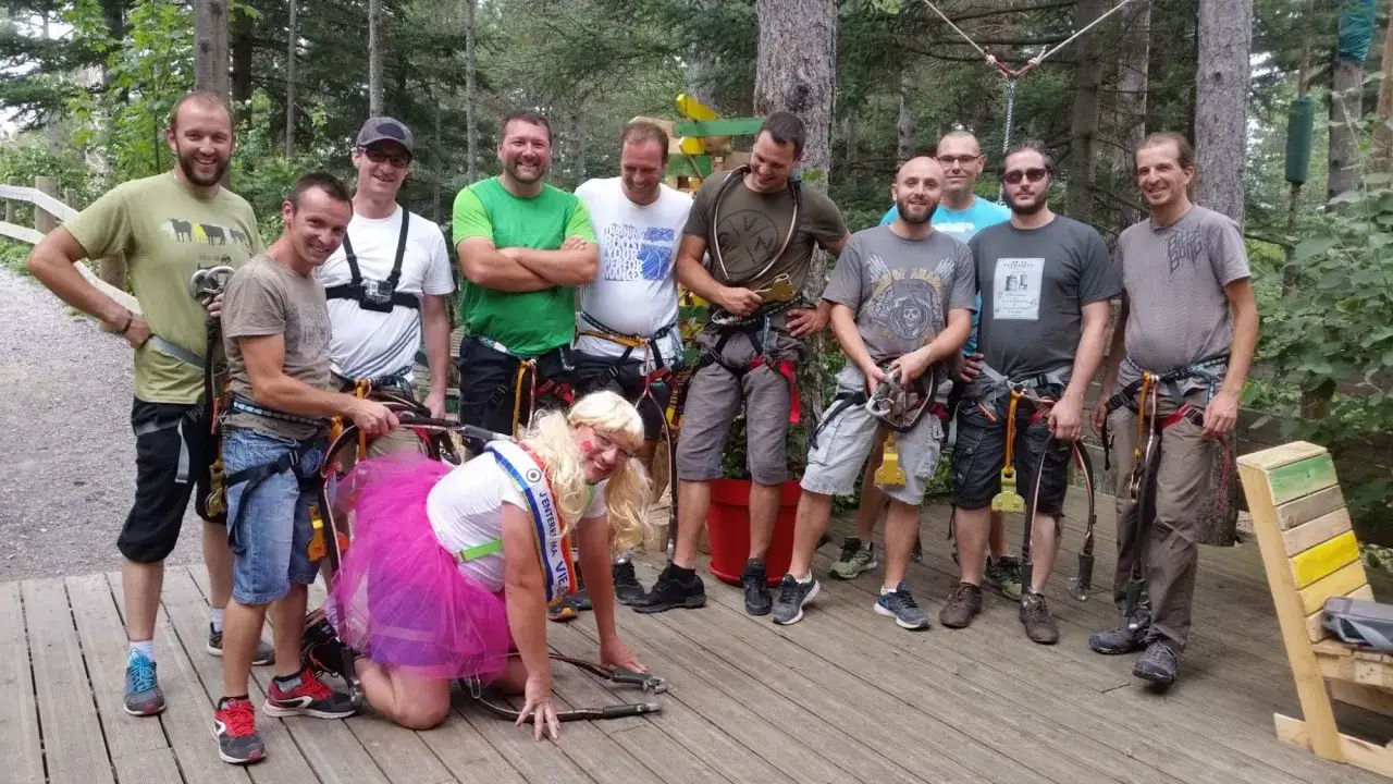 Groupe d'amis en tenue d'activit&eacute; EVG dans un parc aventure, pr&ecirc;ts pour le fun !