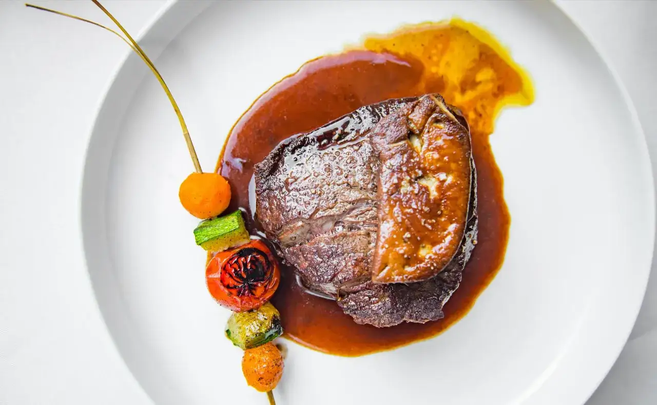 Tournedos Rossini avec foie gras poêlé et légumes grillés. Quel vin avec tournedos Rossini ? Un vin rouge corsé comme un Bordeaux ou un Bourgogne.