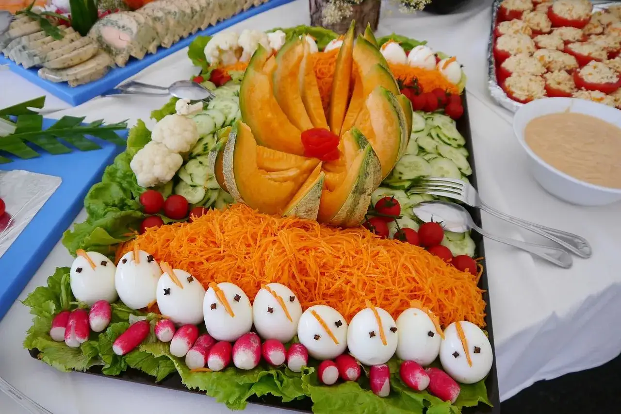 Un buffet froid de salades color&eacute;es : &oelig;ufs d&eacute;cor&eacute;s, carottes r&acirc;p&eacute;es, melon, concombres, tomates cerises et chou-fleur.
