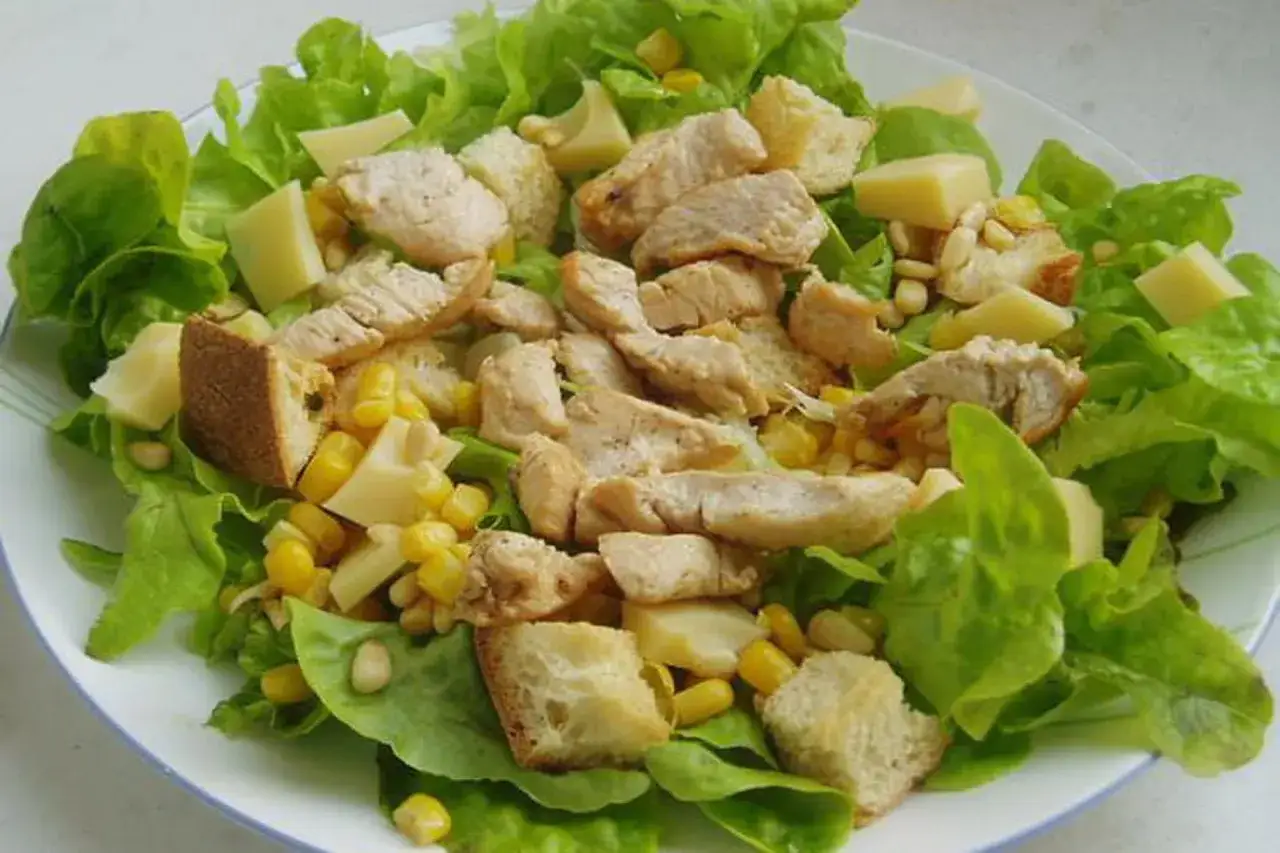 Salade compos&eacute;e avec du poulet grill&eacute;, du ma&iuml;s, des cro&ucirc;tons et des d&eacute;s de fromage. Quelle viande dans une salade compos&eacute;e !