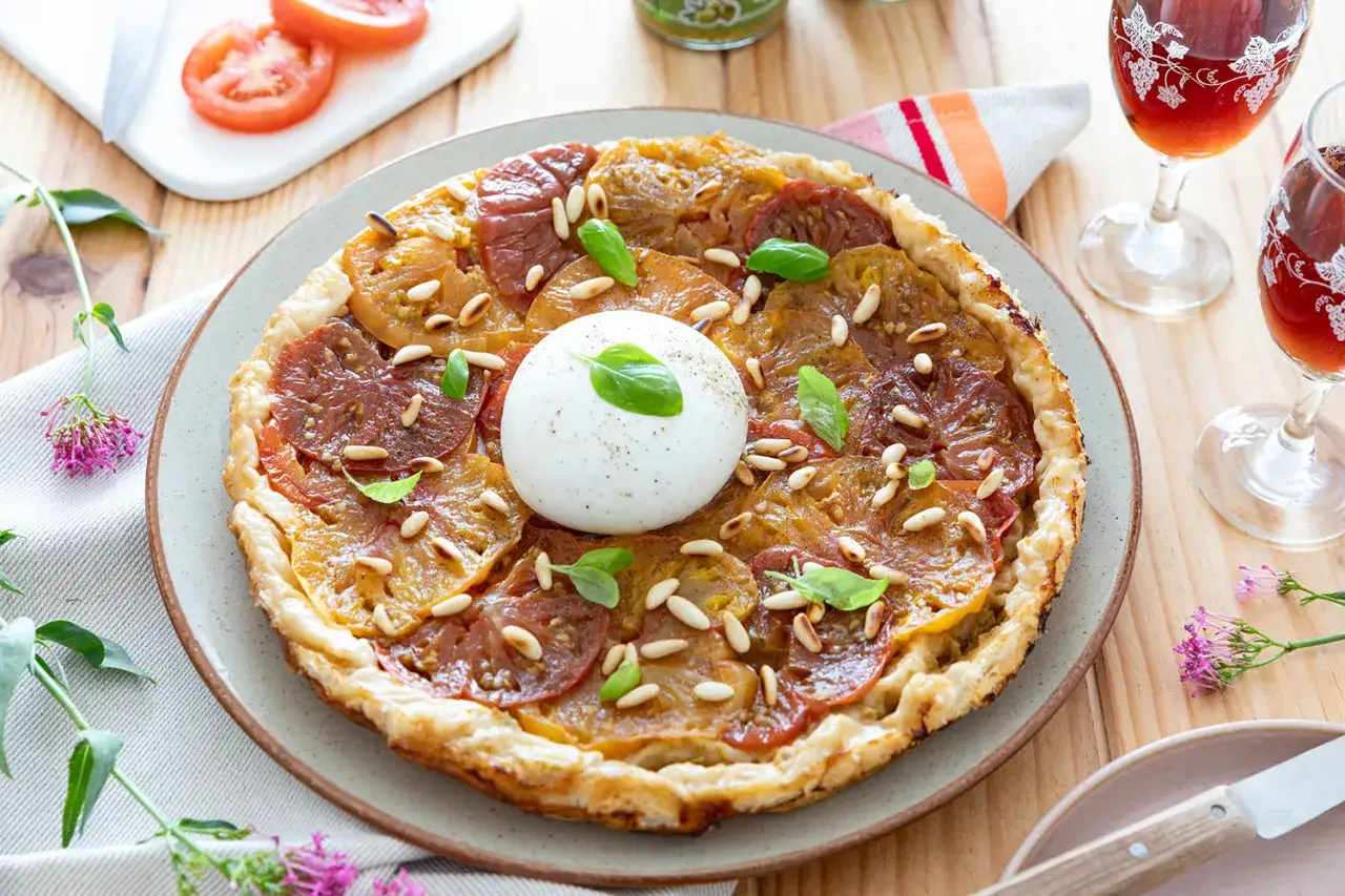 Tarte fine aux tomates multicolores, pignons de pin et burrata cr&eacute;meuse. Un accompagnement tarte tomate parfait pour un repas estival.