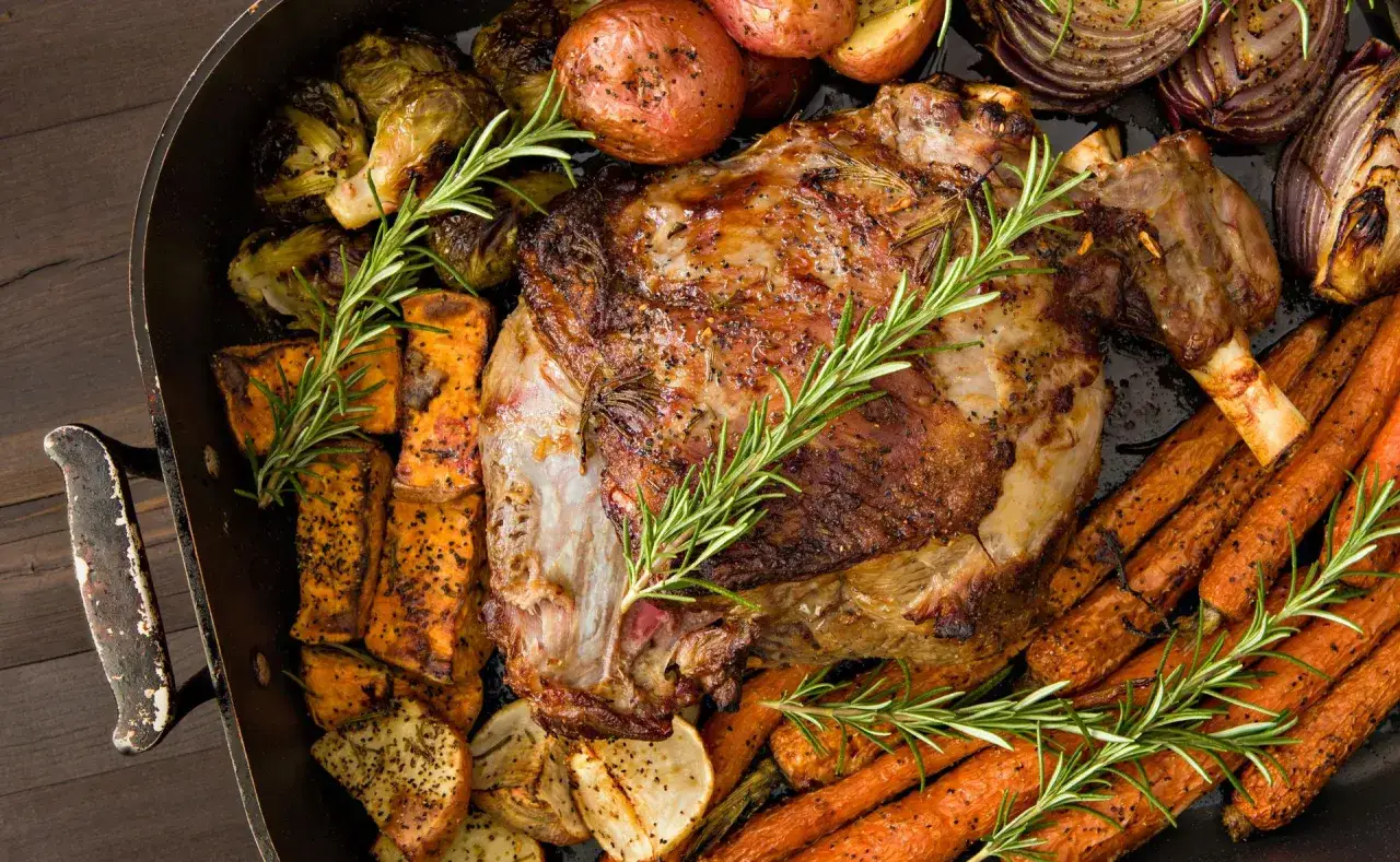 Gigot d'agneau rôti avec légumes racines et romarin. Un plat parfait pour se demander quel vin avec un gigot de 7 heures.