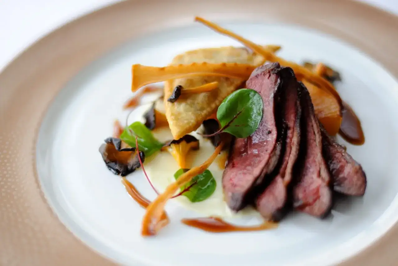 Une d&eacute;licieuse entr&eacute;e chaude de mariage : fines tranches de viande rouge, raviolis croustillants, champignons et pur&eacute;e onctueuse.