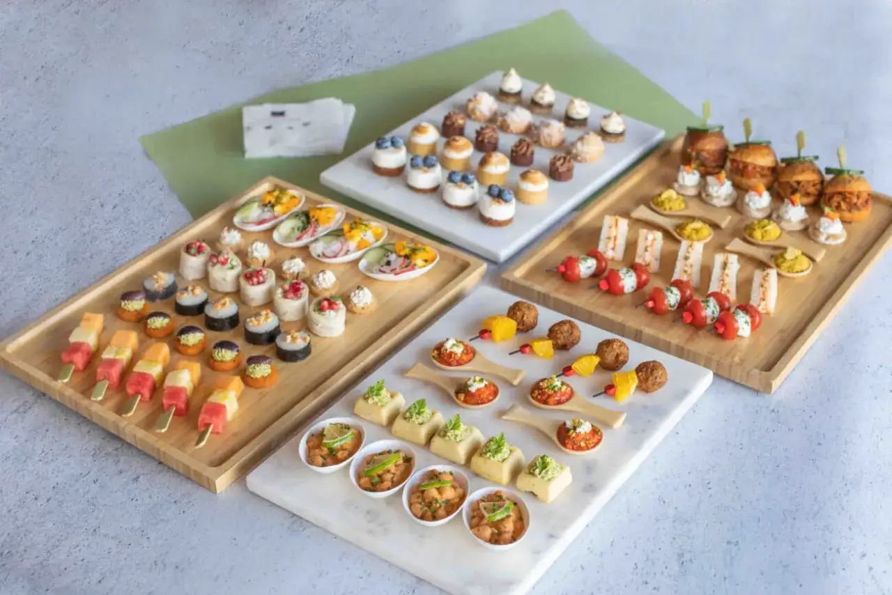 Plateaux vari&eacute;s de bouch&eacute;es, dont des brochettes de fruits, des mini-rouleaux, des verrines v&eacute;g&eacute;tariennes et des mini-burgers.