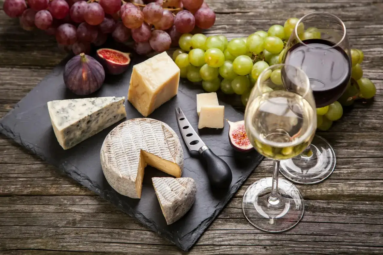 Plateau de fromages variés, raisins, figues et deux verres de vin. Idéal pour savoir quel vin avec fromage de chèvre.