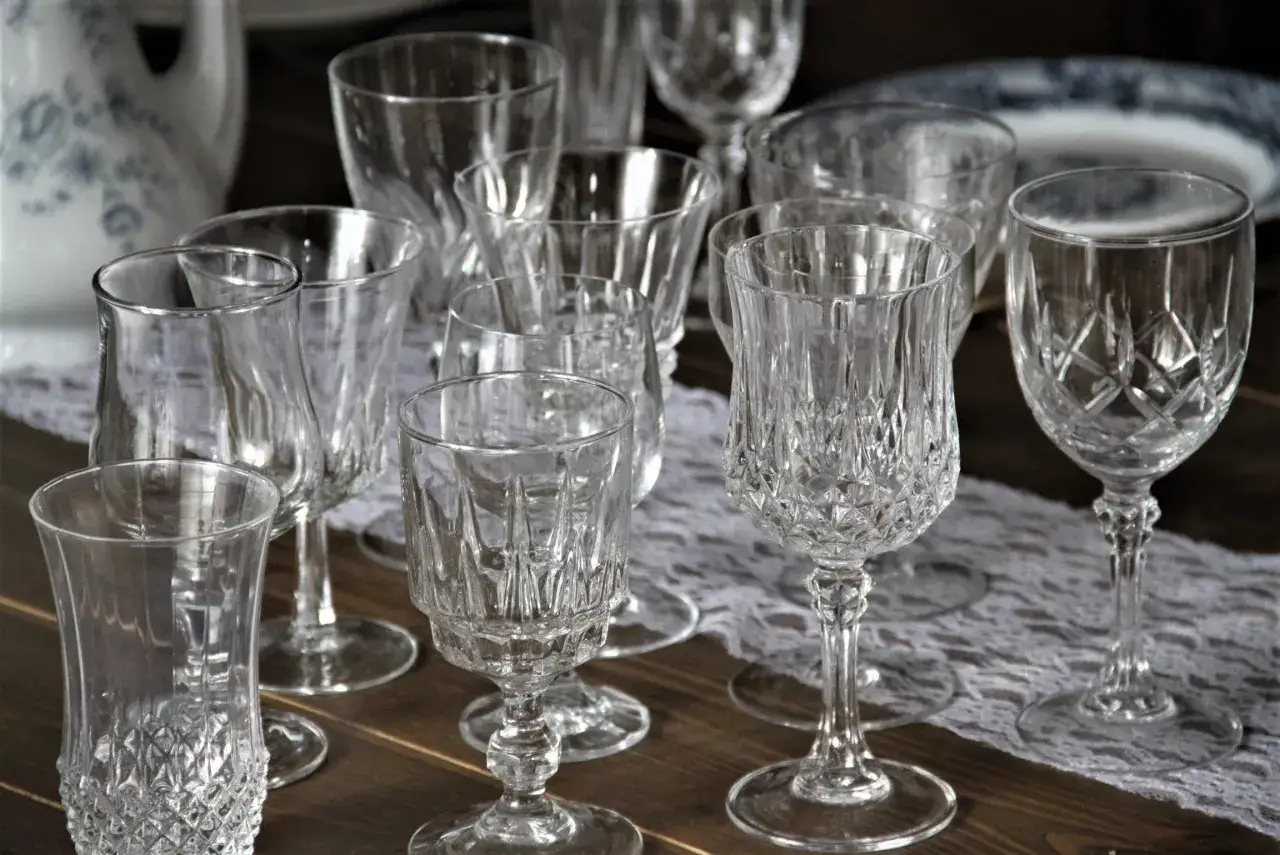 Collection de verres en cristal, certains taillés, d'autres lisses. Combien de verres dans 1 litre ? Difficile à dire sans connaître leur capacité exacte.