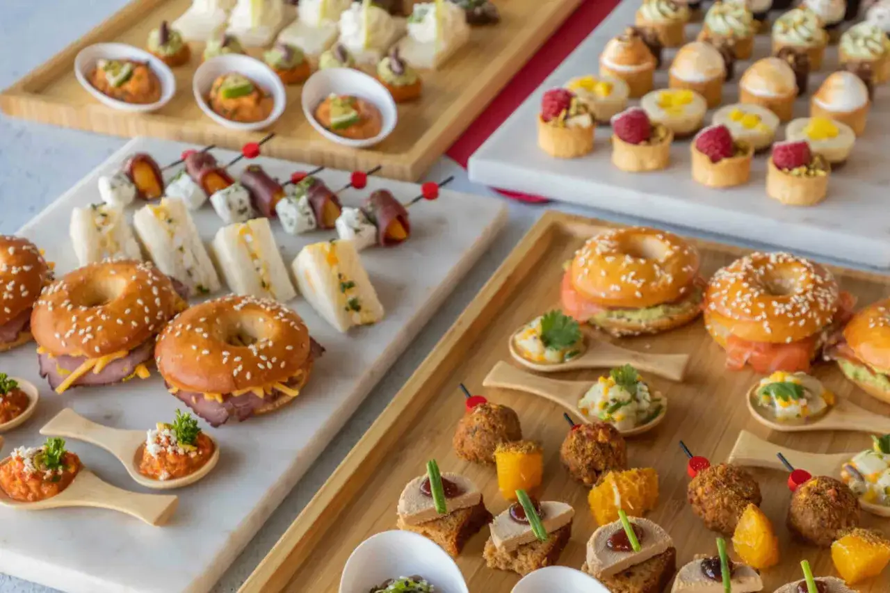 Un assortiment varié de bouchées pour un cocktail apéritif pour 30 personnes : mini-sandwichs, bagels garnis, verrines, brochettes et tartines.