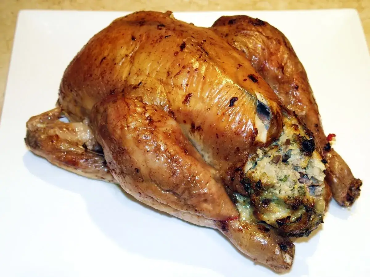 Un chapon farci, doré et savoureux, prêt à être dégusté avec un bon vin.